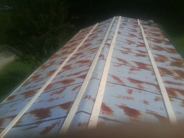 Rusted metal roof panels with new wood purlins before replacement — Storm Damage Roof Repair in Duxbury by Roofing Brothers