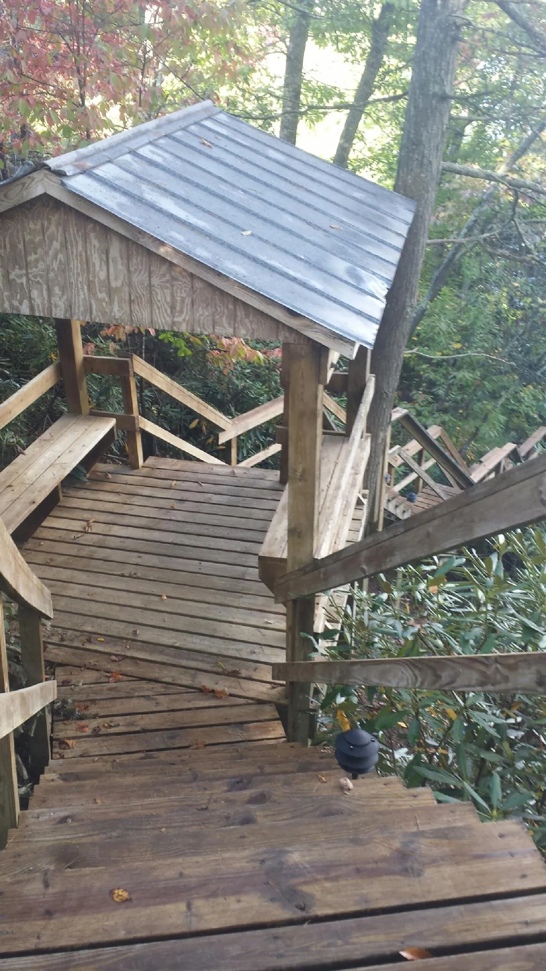 Metal roofed shelter over wooden steps on a wooded walkway — Skylight Repair & Installation work by our crew in Duxbury