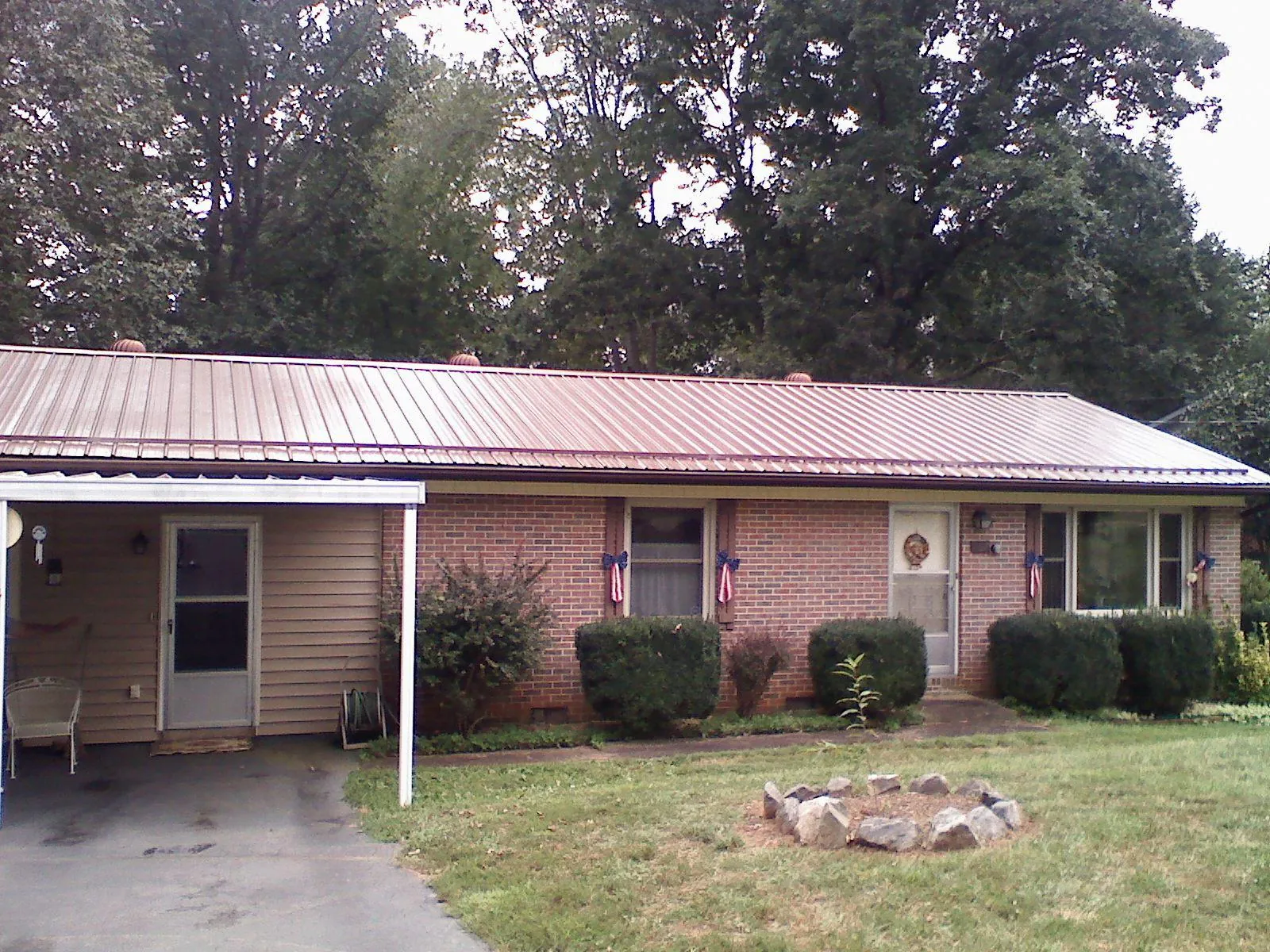 Bronze metal roof and carport on a brick ranch home — Roof Repair work by our crew in Duxbury
